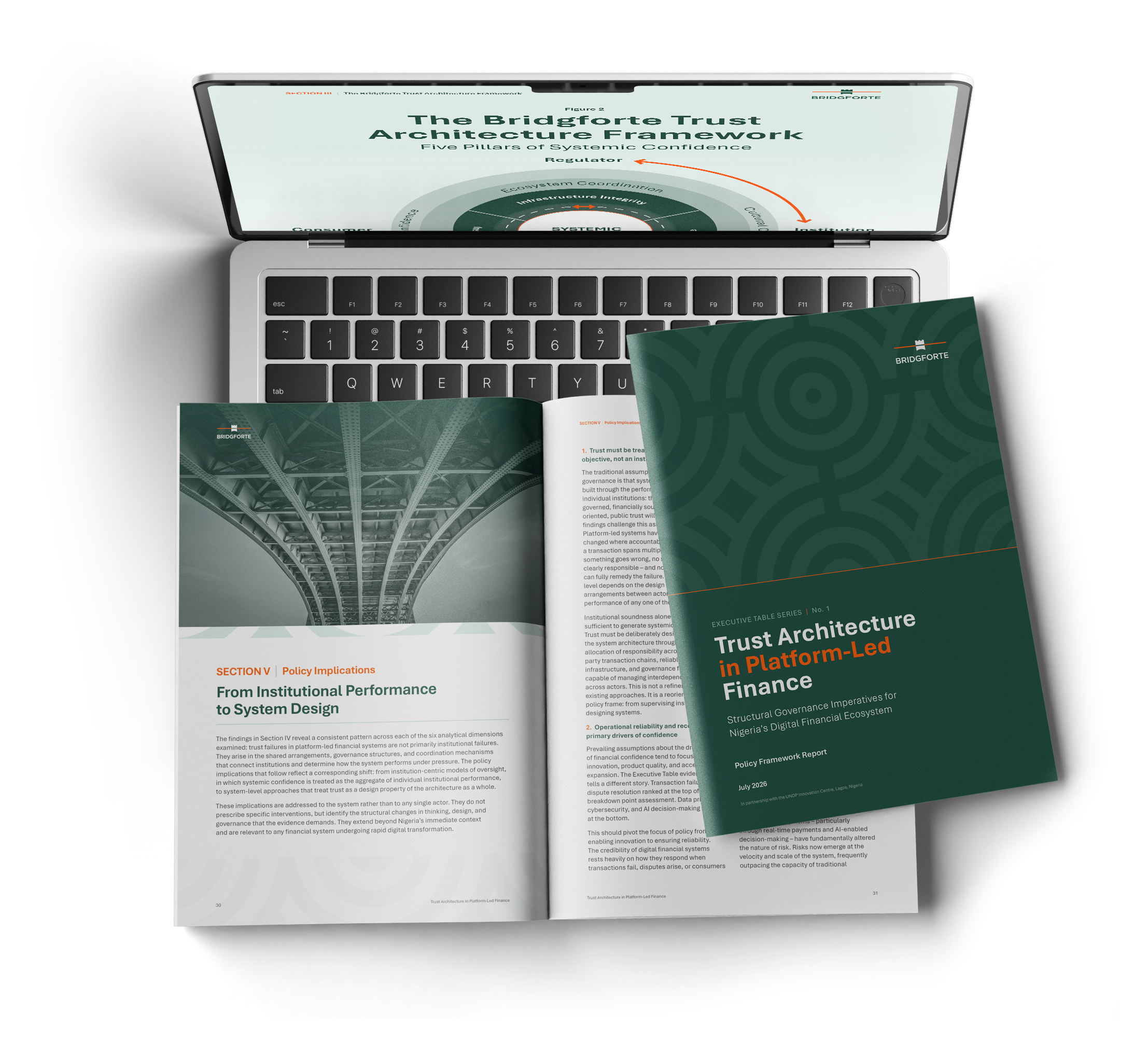 The report on a laptop, alongside the printed cover and an open spread